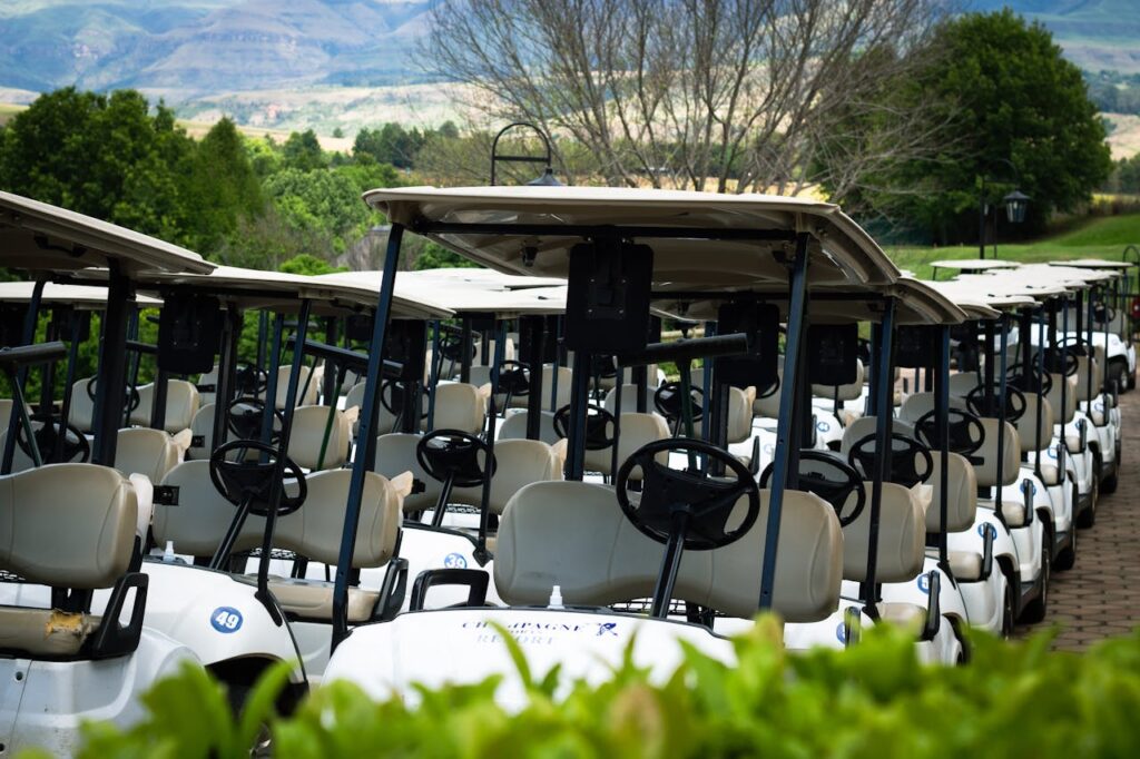 Golf Carts beside Green Trees